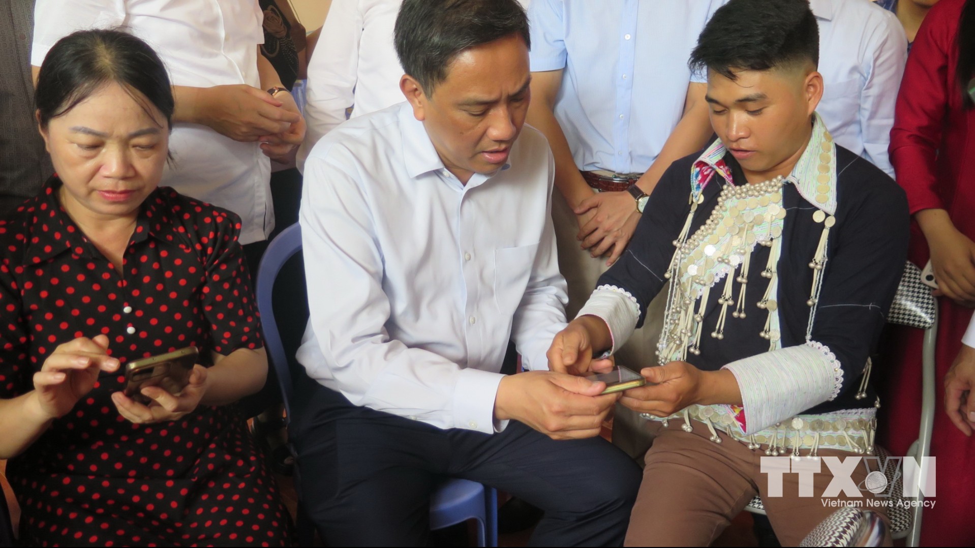 Lãnh đạo tỉnh Lào Cai và người dân xã Bát Xát trải nghiệm các tiện ích "Thôn số" trên thiết bị di động thông minh. (Ảnh: Hương Thu/TTXVN)